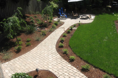 This is an example of a mid-sized traditional full sun backyard concrete paver garden path in Portland.