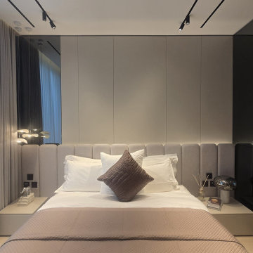 Bedroom with Upholstered Headboard and Mirrored Wall