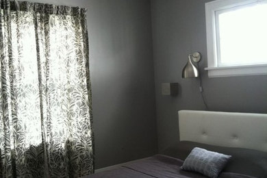 Ejemplo de habitación de invitados bohemia de tamaño medio con paredes grises, suelo de madera pintada y suelo gris