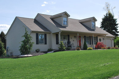 Example of a mid-sized classic beige two-story vinyl exterior home design in Philadelphia with a shingle roof