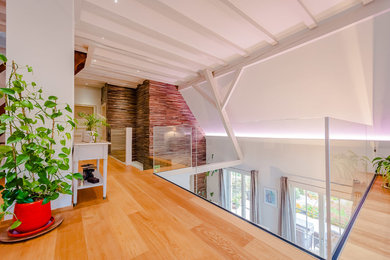 Contemporary family room in Strasbourg with light hardwood floors.