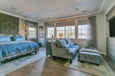 This is an example of a large contemporary master bedroom in Los Angeles with grey walls, light hardwood floors and no fireplace.