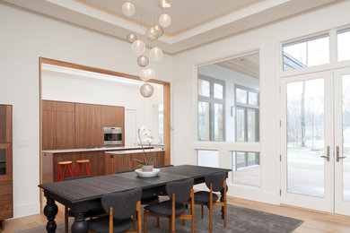 Inspiration for a large contemporary light wood floor and brown floor kitchen/dining room combo remodel in New York with white walls and a two-sided fireplace