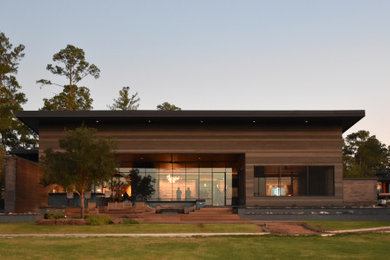 Ejemplo de fachada de casa gris y negra minimalista grande de una planta con revestimiento de madera, tejado de un solo tendido, tejado de metal y tablilla