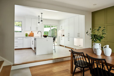 Eat-in kitchen - mid-sized farmhouse u-shaped porcelain tile and gray floor eat-in kitchen idea in Toronto with an undermount sink, shaker cabinets, white cabinets, quartz countertops, white backsplash, ceramic backsplash, stainless steel appliances, a peninsula and white countertops