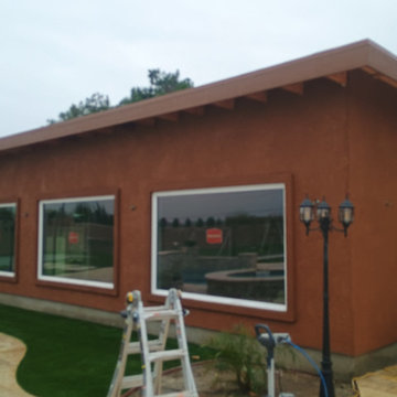 New construction pool house with mini split in landscaping.