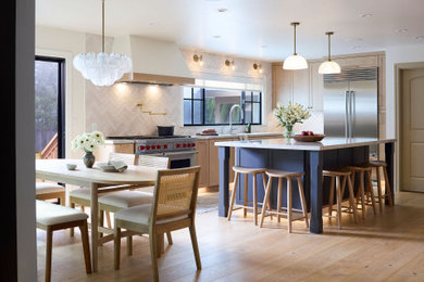 Large transitional l-shaped light wood floor and beige floor eat-in kitchen photo in San Francisco with an undermount sink, shaker cabinets, light wood cabinets, quartzite countertops, white backsplash, ceramic backsplash, stainless steel appliances, an island and multicolored countertops