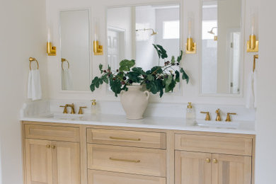 Example of a transitional double-sink bathroom design in Jacksonville with flat-panel cabinets, light wood cabinets and a built-in vanity