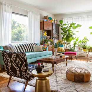 Example of an eclectic open concept medium tone wood floor and brown floor living room design in New York