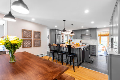 This is an example of a modern kitchen/dining room in Boston with ceramic flooring and grey floors.