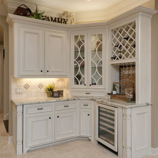 ヒューストンの中サイズのトランジショナルスタイルのおしゃれなホームバー (落し込みパネル扉のキャビネット、白いキャビネット、御影石カウンター、ベージュキッチンパネル、石タイルのキッチンパネル、トラバーチンの床、ベージュの床、白いキッチンカウンター) の写真