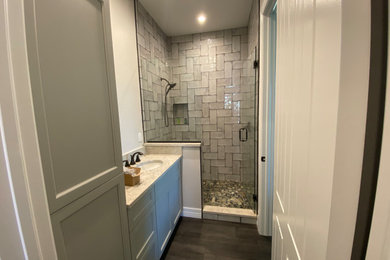 Example of a small country master gray tile and subway tile vinyl floor and gray floor alcove shower design in Miami with shaker cabinets, gray cabinets, a two-piece toilet, white walls, an undermount sink, quartz countertops and a hinged shower door