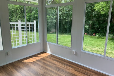 Example of a medium tone wood floor and brown floor sunroom design in New York