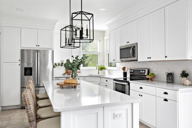 Mid-sized transitional galley ceramic tile and beige floor eat-in kitchen photo in St Louis with an undermount sink, shaker cabinets, white cabinets, quartz countertops, white backsplash, ceramic backsplash, stainless steel appliances, an island and white countertops