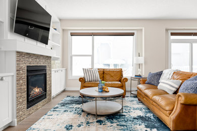 Minimalist medium tone wood floor and wall paneling living room photo in Calgary with a standard fireplace and a tile fireplace