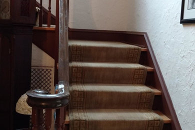 Example of a classic carpeted l-shaped wood railing staircase design in San Diego with carpeted risers