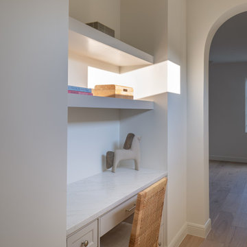 Built-in desk nook with floating shelves and rattan chair