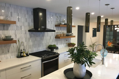Example of a mid-sized trendy l-shaped medium tone wood floor and brown floor eat-in kitchen design in Calgary with an undermount sink, flat-panel cabinets, white cabinets, quartzite countertops, gray backsplash, marble backsplash, stainless steel appliances, an island and white countertops