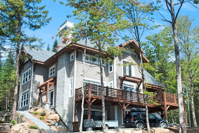 Large contemporary gray two-story wood exterior home idea in Other with a shingle roof