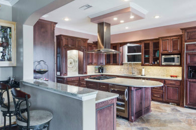 Large traditional u-shaped eat-in kitchen in Dallas with an undermount sink, raised-panel cabinets, dark wood cabinets, quartzite benchtops, beige splashback, stone tile splashback, panelled appliances and with island.