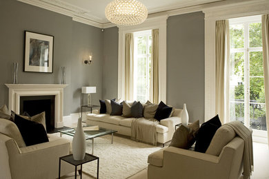 Large elegant formal and enclosed light wood floor living room photo in London with gray walls, a standard fireplace, a stone fireplace and a concealed tv