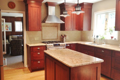 Mid-sized arts and crafts l-shaped light wood floor enclosed kitchen photo in Philadelphia with an undermount sink, shaker cabinets, dark wood cabinets, granite countertops, beige backsplash, stone tile backsplash, stainless steel appliances and an island