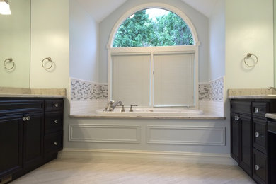Transitional master beige tile and porcelain tile porcelain tile drop-in bathtub photo in Detroit with an undermount sink, recessed-panel cabinets, dark wood cabinets, granite countertops and blue walls