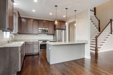 Eat-in kitchen - mid-sized contemporary l-shaped dark wood floor and brown floor eat-in kitchen idea in Chicago with stainless steel appliances, dark wood cabinets, recessed-panel cabinets and a peninsula