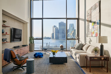 Trendy medium tone wood floor and brown floor living room photo in New York with white walls and a wall-mounted tv