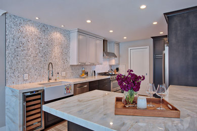 Kitchen - mid-sized modern u-shaped light wood floor kitchen idea in Orange County with a farmhouse sink, flat-panel cabinets, dark wood cabinets, marble countertops, white backsplash, marble backsplash, stainless steel appliances, a peninsula and white countertops
