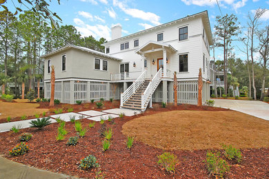 Example of a mid-sized classic white two-story wood house exterior design in Charleston with a hip roof and a shingle roof