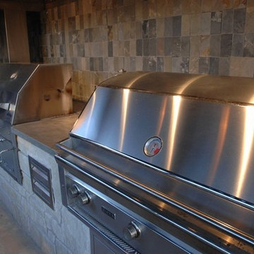 Outdoor Kitchen with Clean Concrete Countertops with Charcoal and Gas Grills