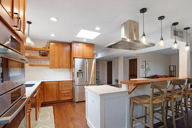 Example of a mid-sized l-shaped dark wood floor and brown floor eat-in kitchen design in Other with an undermount sink, shaker cabinets, white cabinets, quartz countertops, stainless steel appliances, an island and white countertops