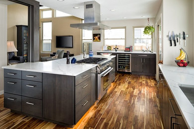 This is an example of a mid-sized modern l-shaped eat-in kitchen in Denver with a single-bowl sink, flat-panel cabinets, dark wood cabinets, quartz benchtops, grey splashback, stone tile splashback, stainless steel appliances, medium hardwood floors, with island, brown floor and white benchtop.