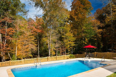Example of a backyard stamped concrete and rectangular pool design in Other