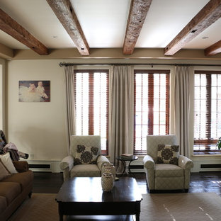 Foto de salón cerrado, mediterráneo, de tamaño medio, con paredes beige, suelo de madera oscura, chimenea tradicional, marco de chimenea de ladrillo y televisor colgado en la pared