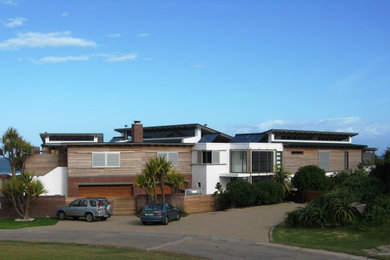 Example of a large trendy white two-story mixed siding exterior home design in Other with a metal roof