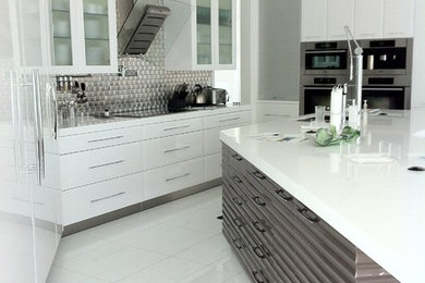 Mid-sized trendy u-shaped porcelain tile eat-in kitchen photo in Miami with flat-panel cabinets, white backsplash, stainless steel appliances, an island, an undermount sink, white cabinets, quartz countertops and glass tile backsplash