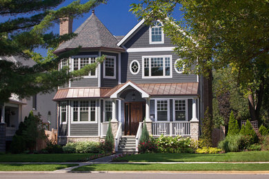 This is an example of a large traditional three-storey grey exterior in Chicago with wood siding.