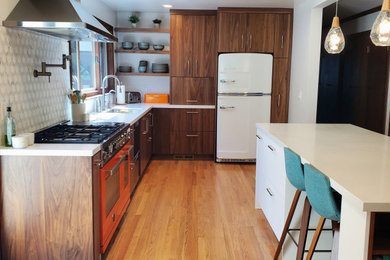 サンフランシスコにある広いミッドセンチュリースタイルのおしゃれなキッチン (アンダーカウンターシンク、フラットパネル扉のキャビネット、中間色木目調キャビネット、クオーツストーンカウンター、カラー調理設備、淡色無垢フローリング) の写真