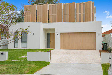 Inspiration for a mid-sized modern two-storey white house exterior in Sydney with mixed siding, a flat roof, a metal roof and a white roof.
