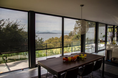 Photo of a large contemporary kitchen/dining combo in Seattle with concrete floors, no fireplace and white walls.