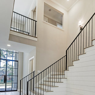 Ejemplo de escalera en U y machihembrado, tradicional renovada, grande, con escalones de madera, contrahuellas de madera pintada, barandilla de metal y machihembrado