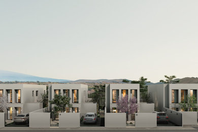 Imagen de fachada de casa blanca mediterránea grande de dos plantas con revestimiento de estuco y tejado plano