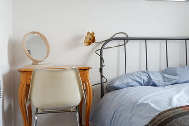 Small contemporary guest bedroom in Manchester with white walls, laminate floors and brown floors.