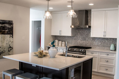 Example of a mid-sized transitional l-shaped medium tone wood floor and gray floor open concept kitchen design in Vancouver with gray backsplash, mosaic tile backsplash, a double-bowl sink, recessed-panel cabinets, white cabinets, solid surface countertops, stainless steel appliances and an island