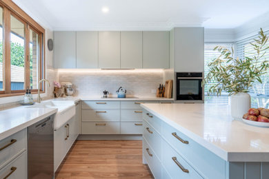 Mittelgroße Küche mit Schrankfronten im Shaker-Stil, grünen Schränken, Quarzwerkstein-Arbeitsplatte, Küchenrückwand in Beige, Rückwand aus Keramikfliesen und weißer Arbeitsplatte in Melbourne