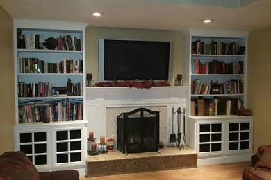 Example of a classic family room design in Los Angeles with a standard fireplace and a wood fireplace surround
