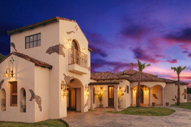 Mid-sized tuscan beige two-story adobe exterior home photo in Albuquerque with a hip roof