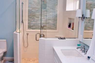 Photo of a medium sized traditional shower room bathroom in Other with recessed-panel cabinets, white cabinets, a corner shower, a one-piece toilet, beige tiles, blue tiles, mosaic tiles, blue walls, ceramic flooring, a submerged sink and solid surface worktops.